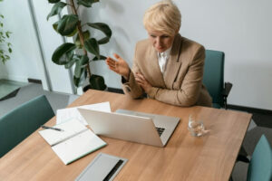 Woman wearing business attire in a conference room, using Copilot for Teams.