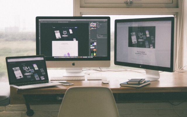 Laptop, computer, and extra monitor on desk