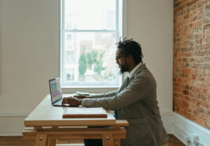 Man in suit sitting at a laptop using Microsoft Excel