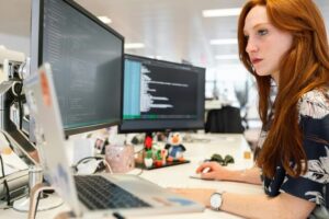 Woman sitting at a computer working on Threat Exposure Management